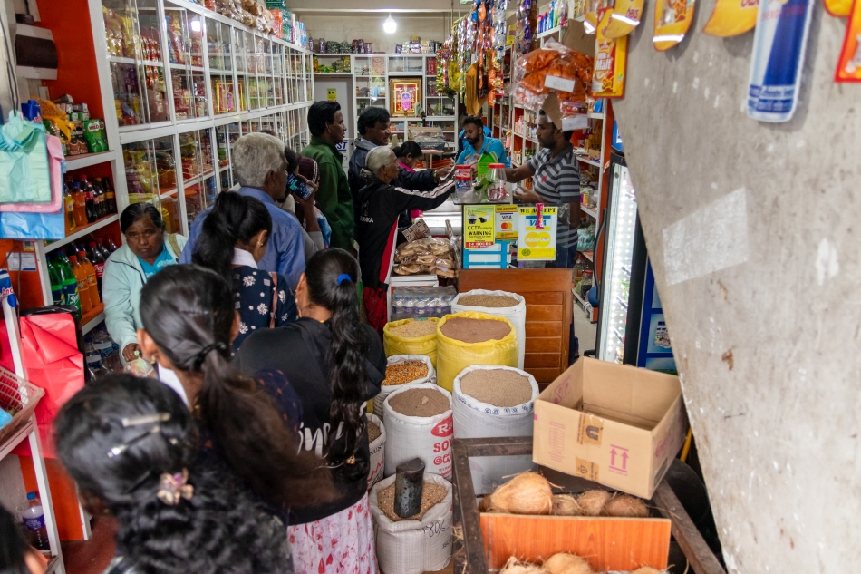 Community members exchange their emergency coupons for dry rations at a local shop on day two of the exercise. These will be pooled when the residents arrive at the evacuation center and nutritious meals cooked for them until they can return to their homes safely.