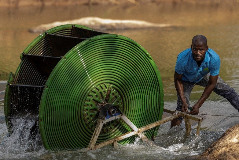 A farmer in Malawi installing a hydro-powered water pump. Photo: GIZ